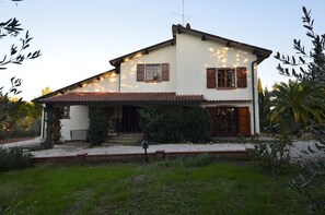 A two-story house with a sloped roof, a front porch, and a small garden area. - Mills 6, a well-equipped family home with a large garden (Guardistallo)