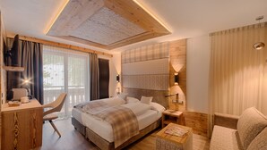 Ein modernes Hotelzimmer mit einem großen Bett, einem Schreibtisch, einem Stuhl und einer Couch.