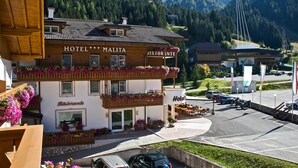Ein Hotel mit Balkon, Sitzgelegenheit im Freien und Bergblick.