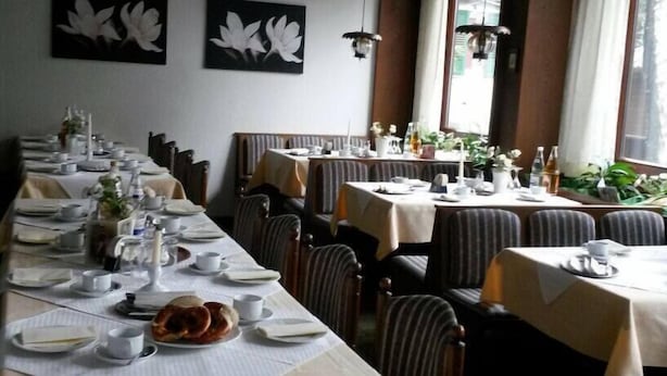 A restaurant with long tables set for dining, featuring white tablecloths and a variety of dishes. - Hotel Gasthof Ratstube (Kirchheim unter Teck)