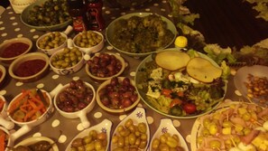 A table with various dishes including olives, salads, and meats.
