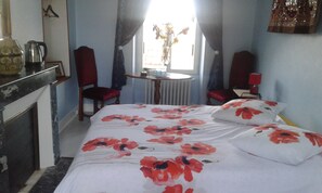 A bedroom with a bed, a chair, a table, and a radiator. - L'Isle de Bourbon (Le Gue-de-Velluire)