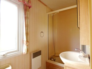 A bathroom with a window, a shower, and a sink. - Caravan Hire at Sunnydale Holiday Park (Louth)