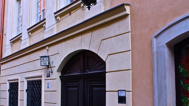 A building with a street lamp, double doors, and a sign indicating the address. - Old Town Snug (Warsaw)