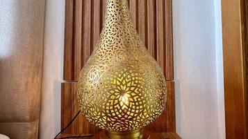 A brass table lamp with intricate cut-out patterns on a wooden table.