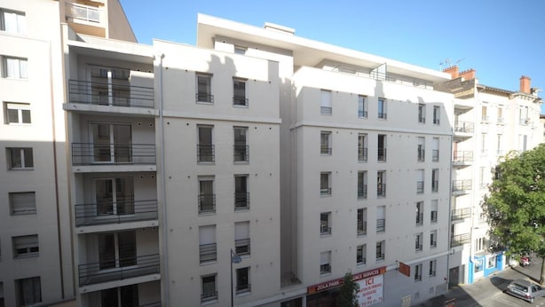 A multi-story building with balconies, a sign for Zola Park, and a parking sign. - Studilodge - Zola Park (Villeurbanne)