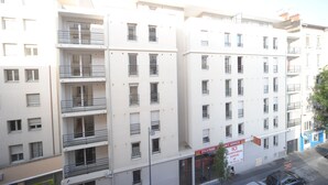 A multi-story building with balconies, a sign for Zola Park, and a parking sign. - Studilodge - Zola Park (Villeurbanne)