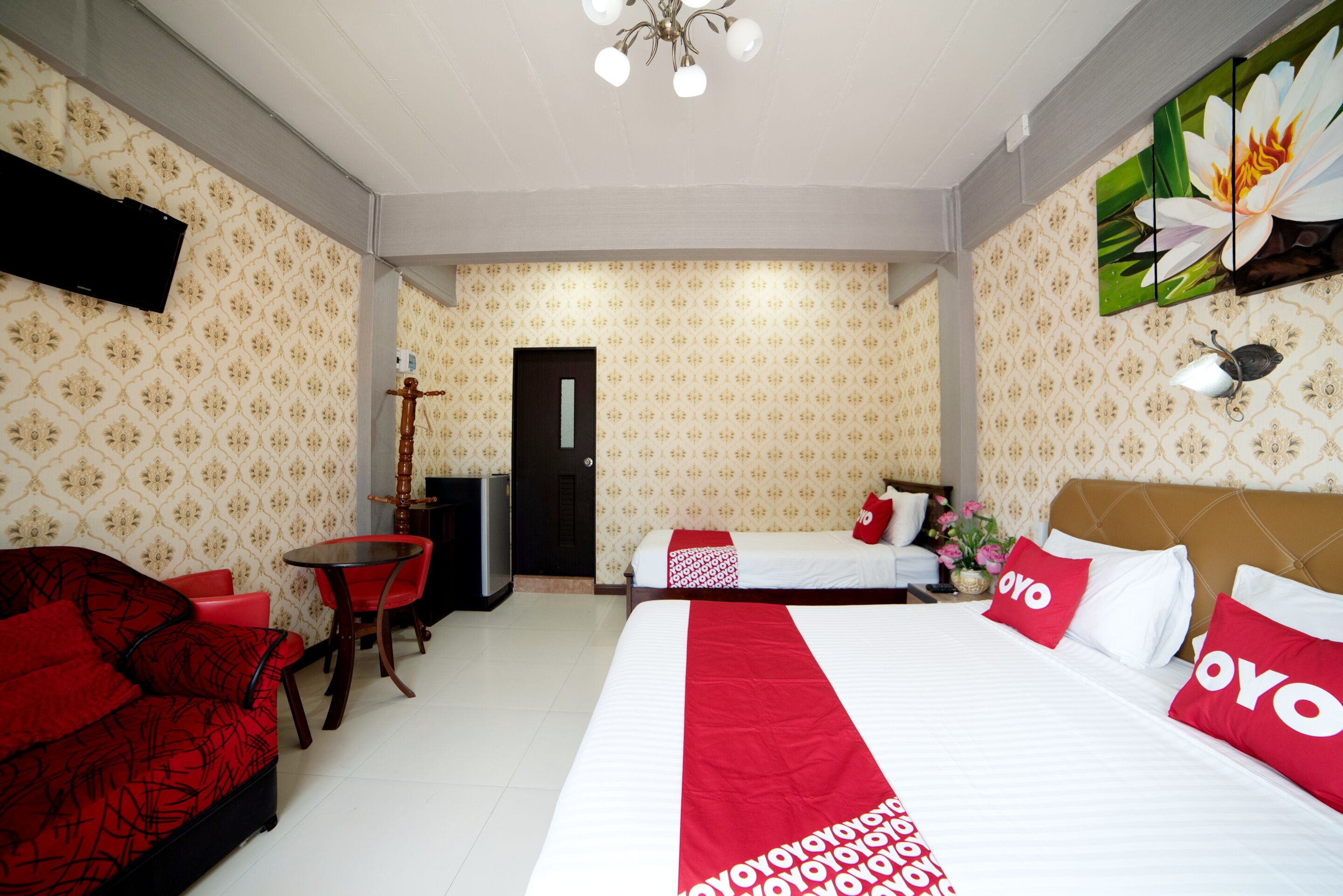 A hotel room with a bed, a desk, a chair, a TV, and a door.