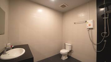 Un baño pequeño y moderno con inodoro, lavamanos y cabina de ducha.