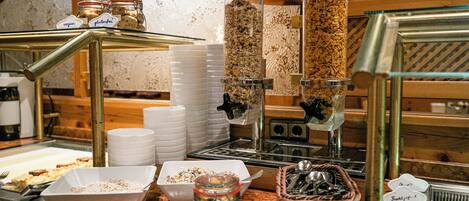 Zona de buffet con varios recipientes de comida, incluyendo frascos y cuencos, y un letrero que indica opciones sin gluten.