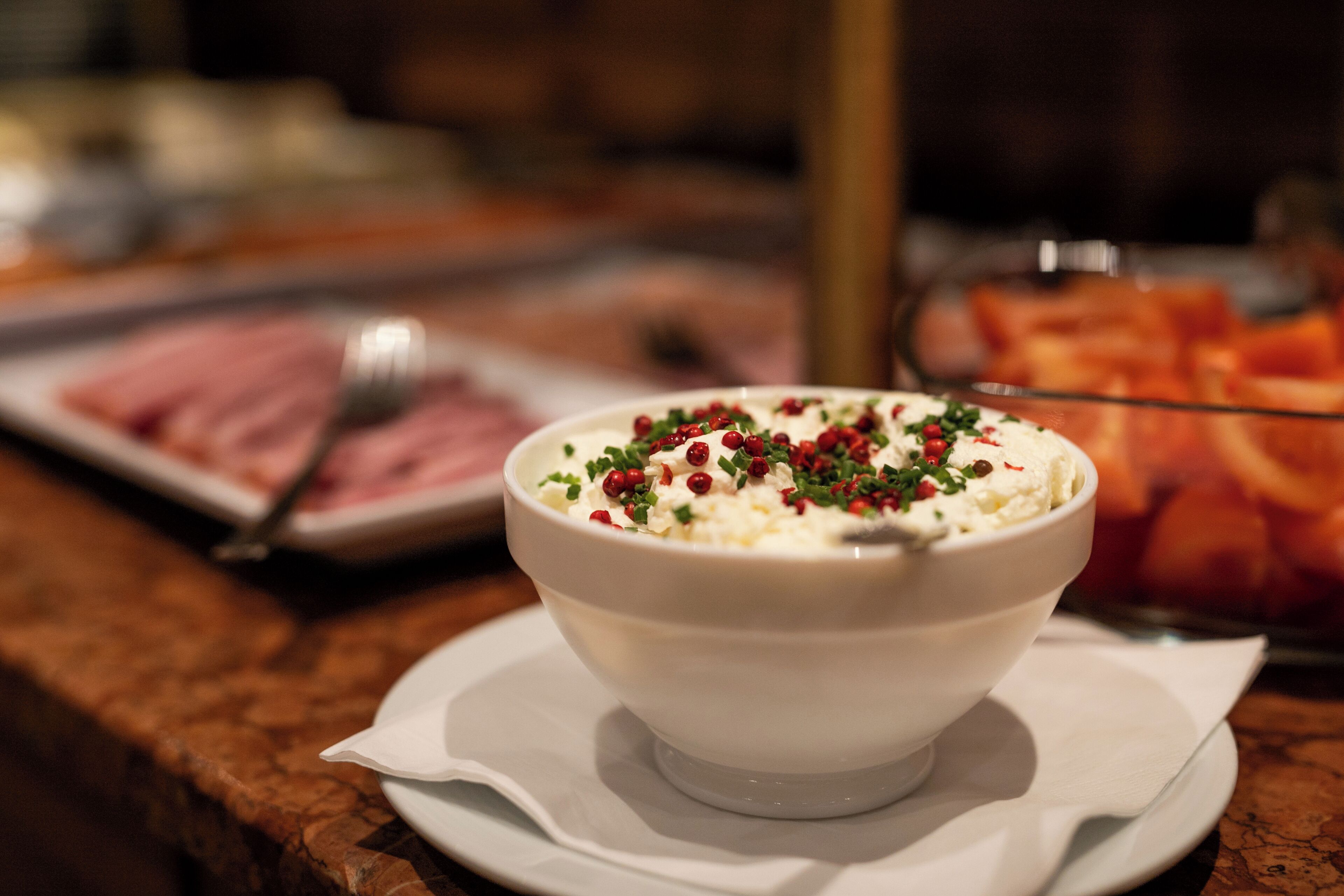 Un plato blanco con comida, una servilleta y una encimera de mármol.