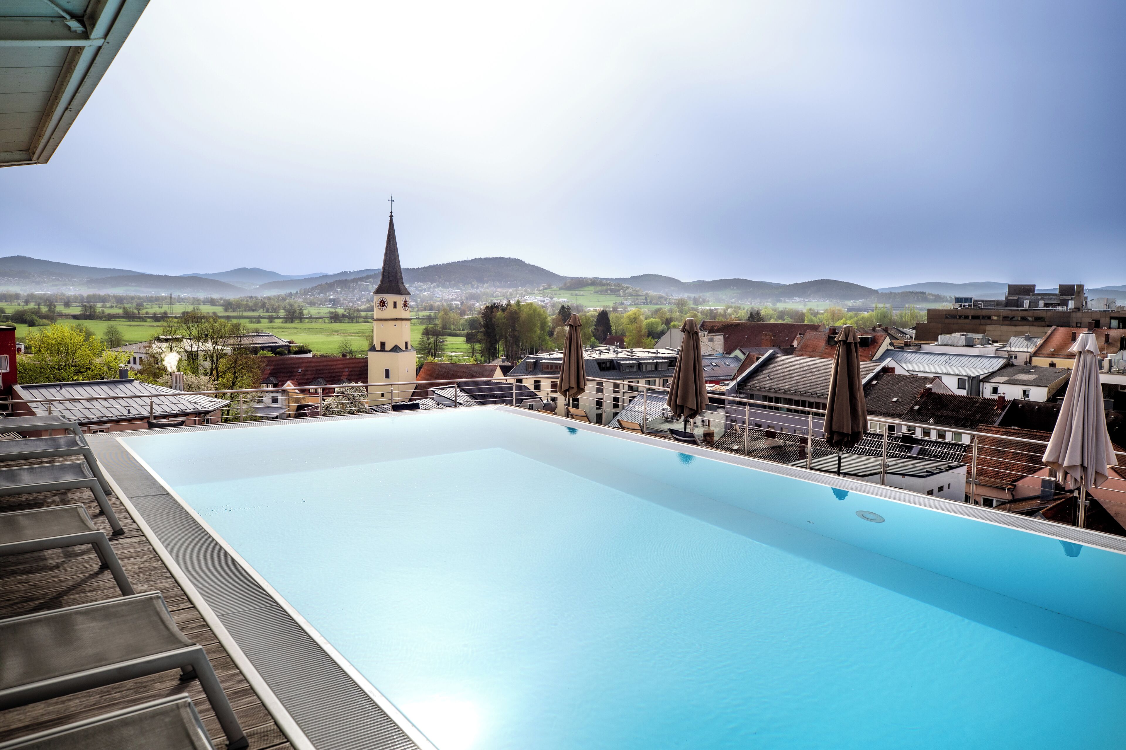 A rooftop swimming pool with a view of a church and surrounding buildings.