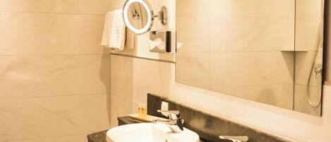Un baño moderno con dos lavamanos, un espejo grande y una ducha.