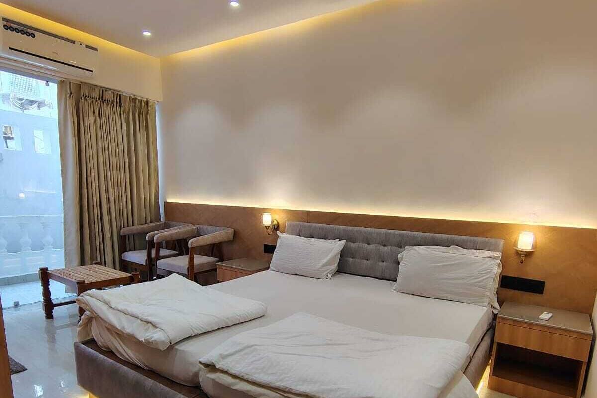 Een moderne hotelkamer met een groot bed, nachtkastjes, een zithoek en uitzicht op de omgeving.