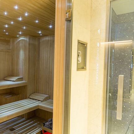 A sauna room with wooden benches and a glass door.