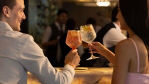 Een stel dat met drankjes proost in een bar.