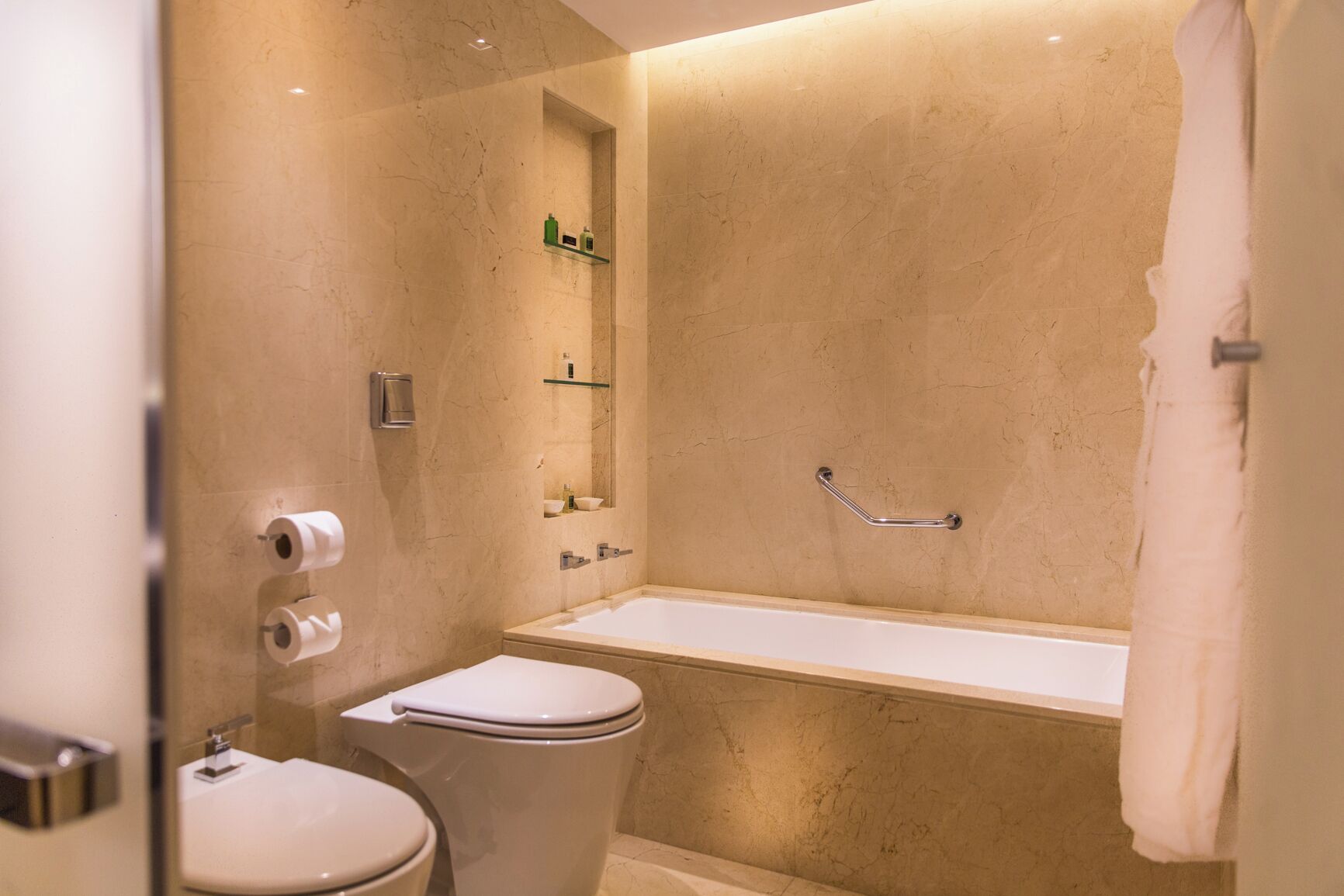 A bathroom with a bathtub, toilet, and a glass shower enclosure.