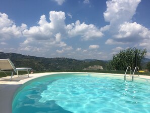 Una piscina al aire libre, tumbonas