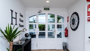 A hotel entrance with a sign reading "Suite Home Pinares" and a "SALIDA" sign above the door. - Suite Home Pinares (Santander)