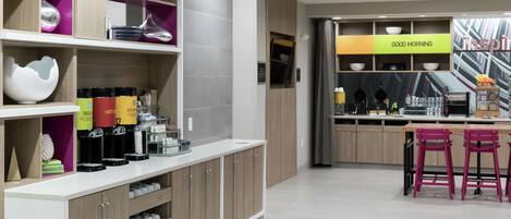 A modern kitchen with a breakfast bar, shelves with kitchenware, and a 'GOOD MORNING' sign.