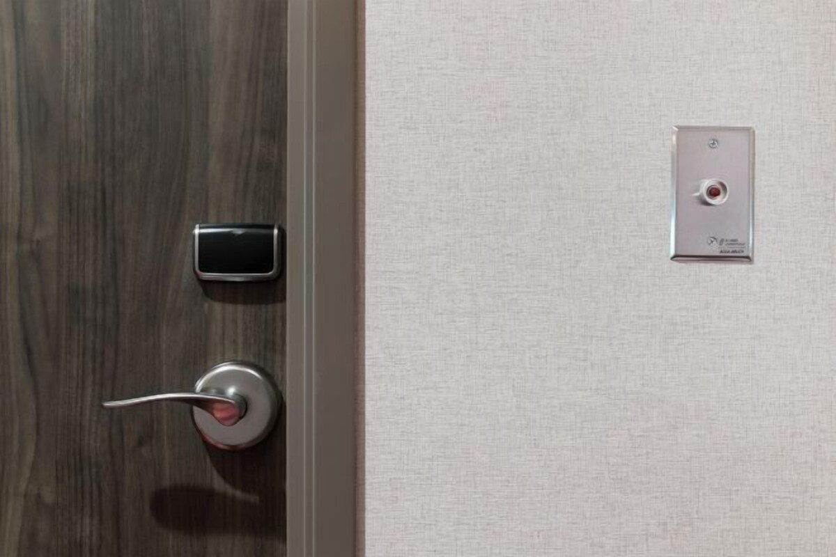 A door with a modern lock and a control panel on the wall.