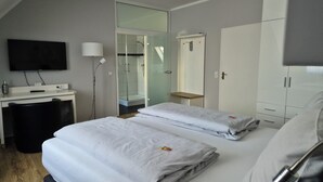 A modern hotel room with a bed, a desk, a TV, and a wardrobe. - Hotel Meyer (Bergheim)