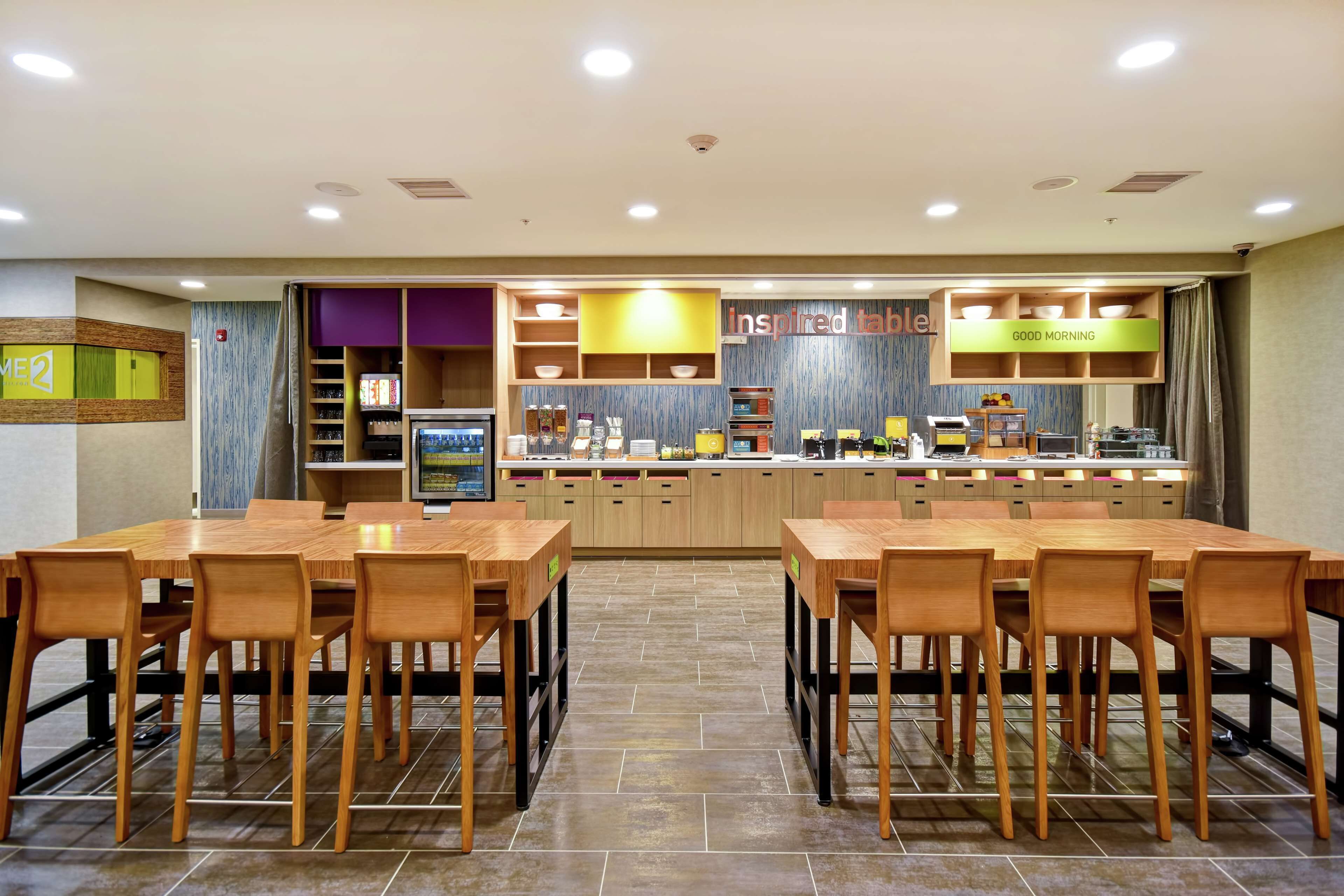 Un restaurant avec un comptoir, plusieurs tables et des chaises.