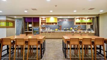 Un restaurant avec un comptoir, plusieurs tables et des chaises.