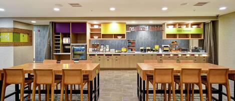 A restaurant with a counter, multiple tables, and chairs.