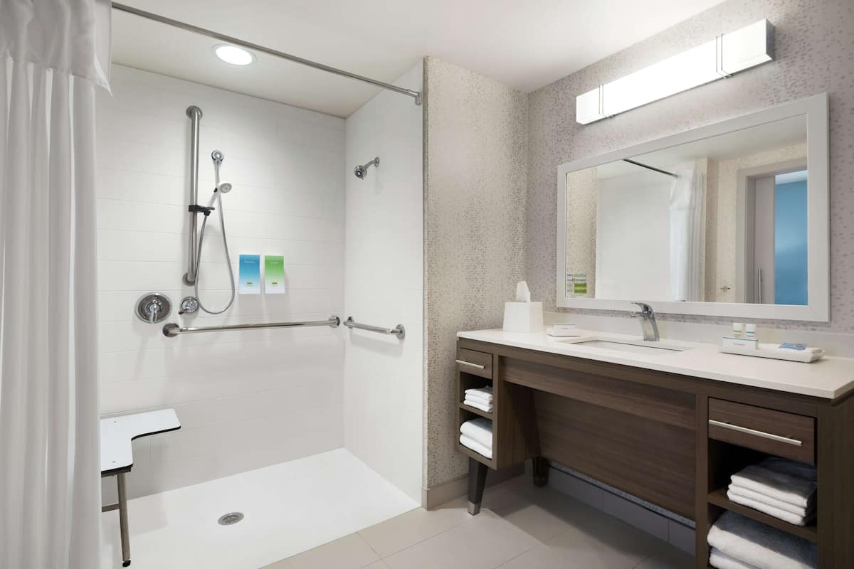 Ein modernes Badezimmer mit Dusche, Waschbecken und Waschtisch.