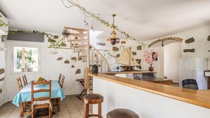 Une cuisine rustique avec un comptoir en bois, des murs en pierre et un luminaire suspendu.