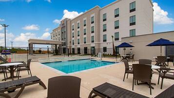 Una piscina al aire libre de temporada, sombrillas