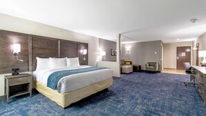 A hotel room with a large bed, bedside tables, a desk, and a chair. - Comfort Suites Humble Houston IAH (Humble)