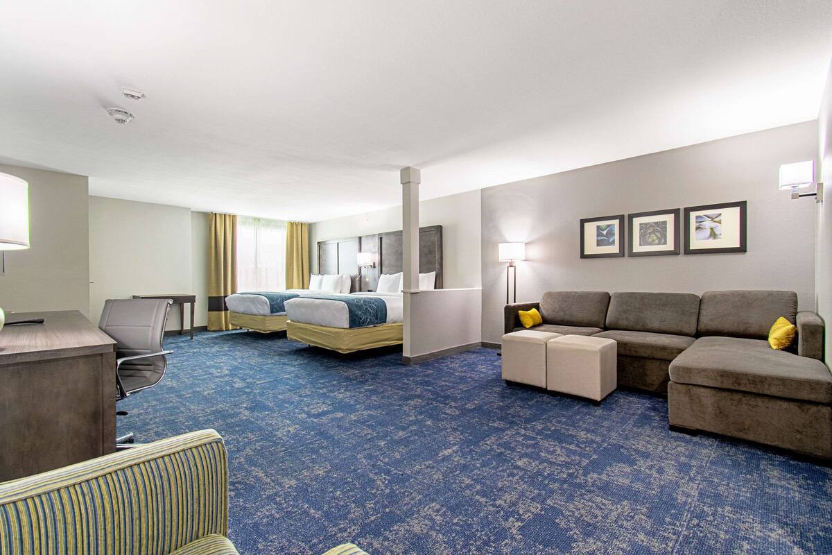 Een hotelkamer met een groot bed, een slaapbank, een bureau en een stoel.