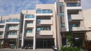 Um edifício de vários andares com design arquitetônico moderno, com varandas e janelas amplas.