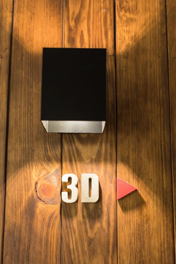 Un plancher en bois sur lequel se trouve un objet noir, et on peut y voir le chiffre 3D.