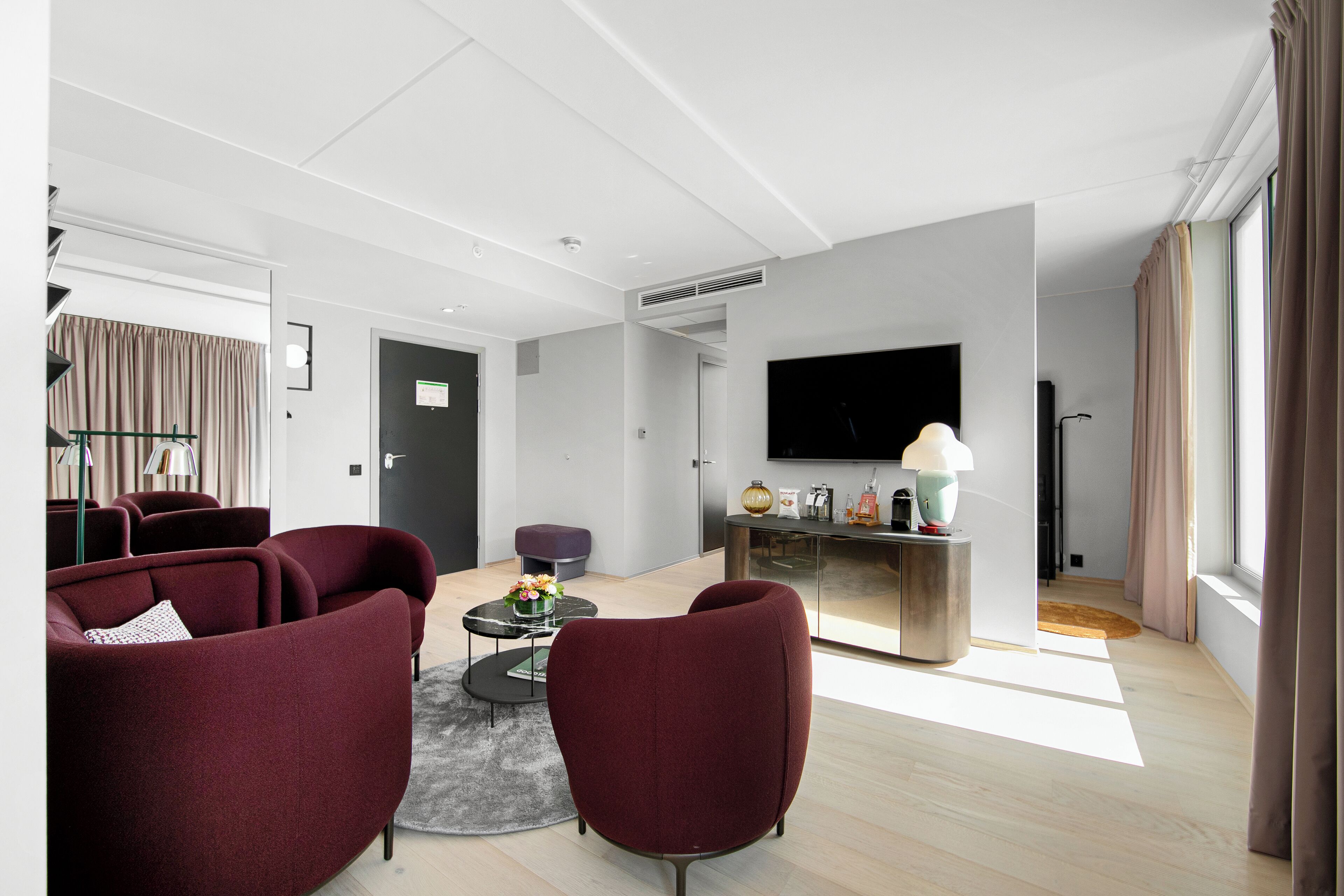 A modern living room with a sofa set, a coffee table, and a flat-screen TV.