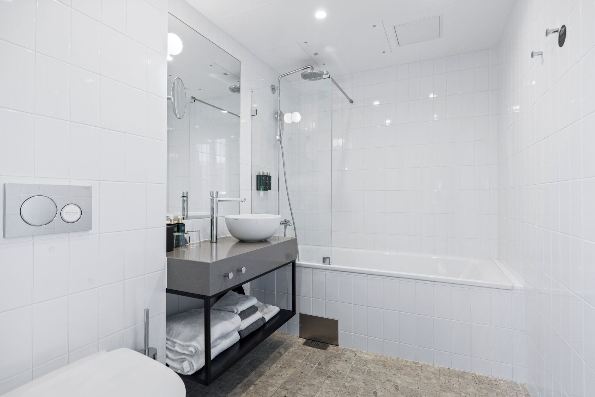 A modern bathroom with a white sink, a bathtub, and a shower.