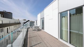 Ein modernes Gebäude mit großen Fenstern und einer Holzterrasse.