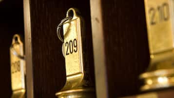 Brass room numbers on a wooden shelf.