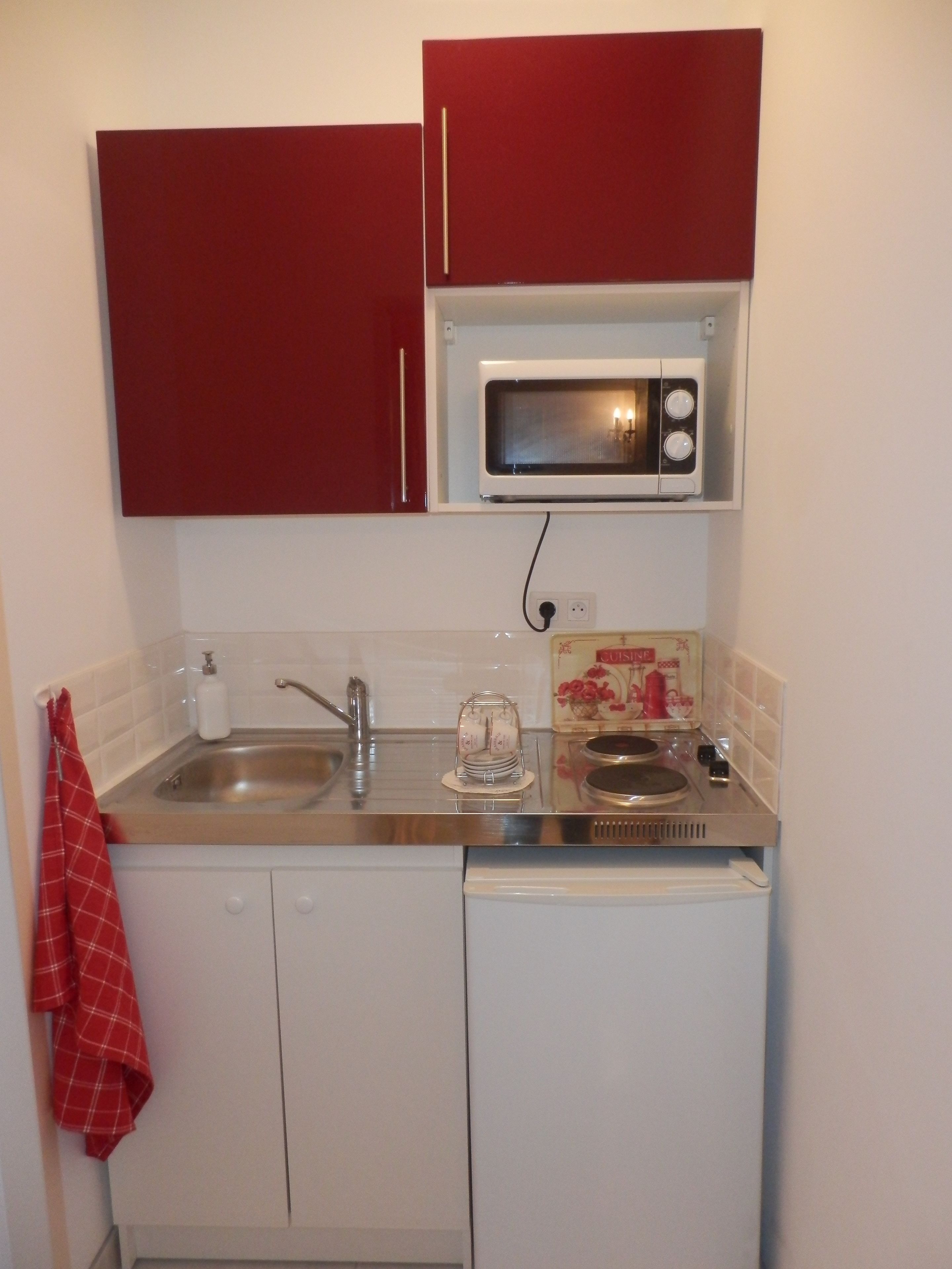 A compact kitchen with a microwave, sink, and dishwasher.