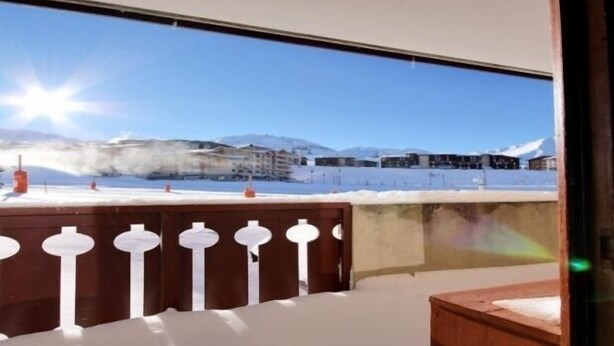 Ein Zimmer mit Blick auf eine verschneite Landschaft und Berge.