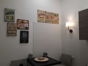 Un baño pequeño y moderno con encimera negra, un lavabo y una lámpara de pared.