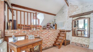 A rustic kitchen with exposed brick walls, wooden beams, and a large mirror. - Homerez - Peaceful countryside house in Mer (Mer)