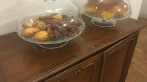 Two glass-covered dessert displays on a wooden cabinet. - Robin Rooms (Montegranaro)