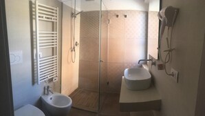A modern bathroom with a glass-enclosed shower, two sinks, and a toilet. - Robin Rooms (Montegranaro)