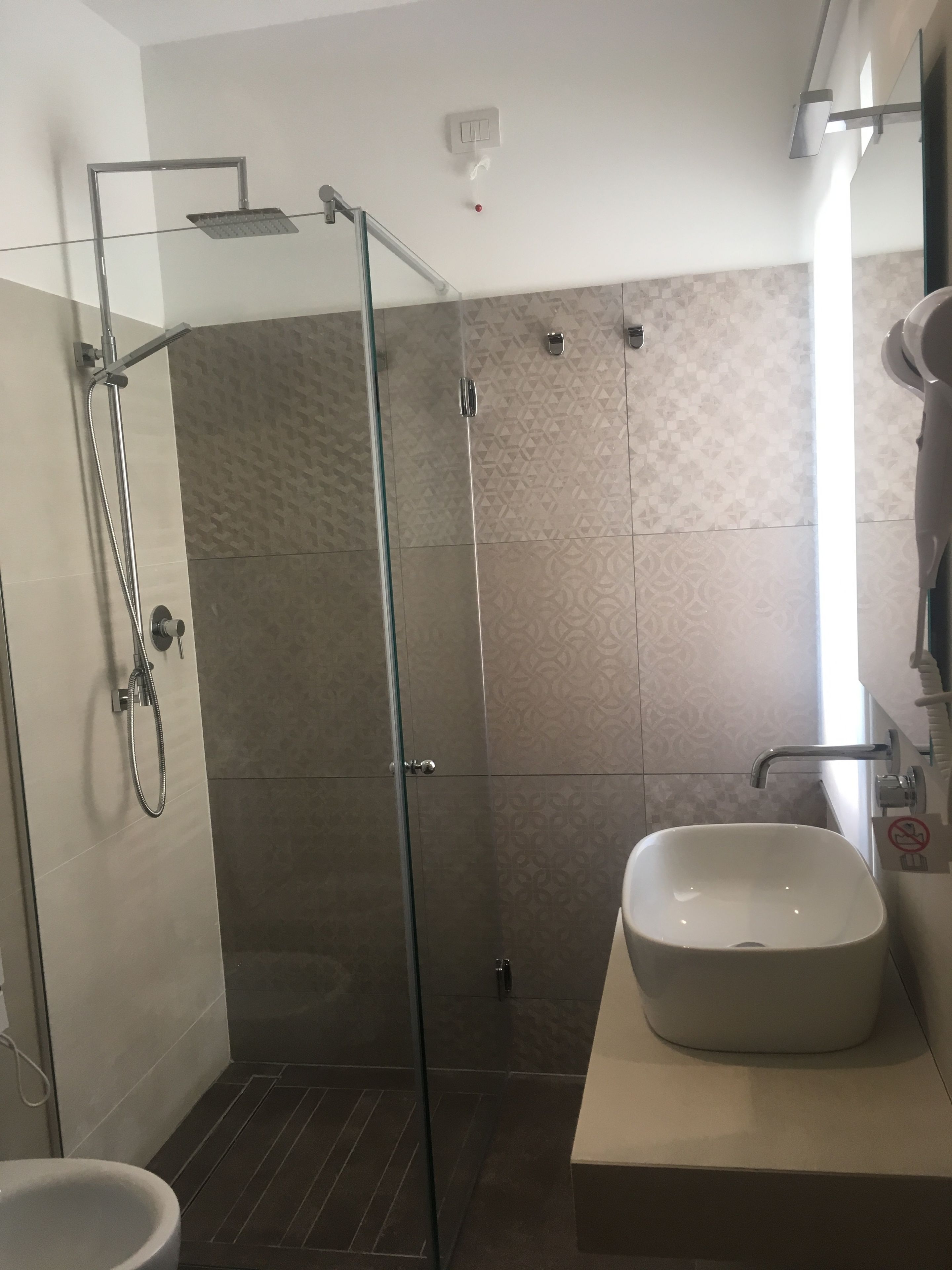 Ein modernes Badezimmer mit einer Duschkabine, einem Waschbecken und einer Toilette.