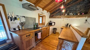 A kitchen with wooden cabinets, a sink, a microwave, and a wine cooler.