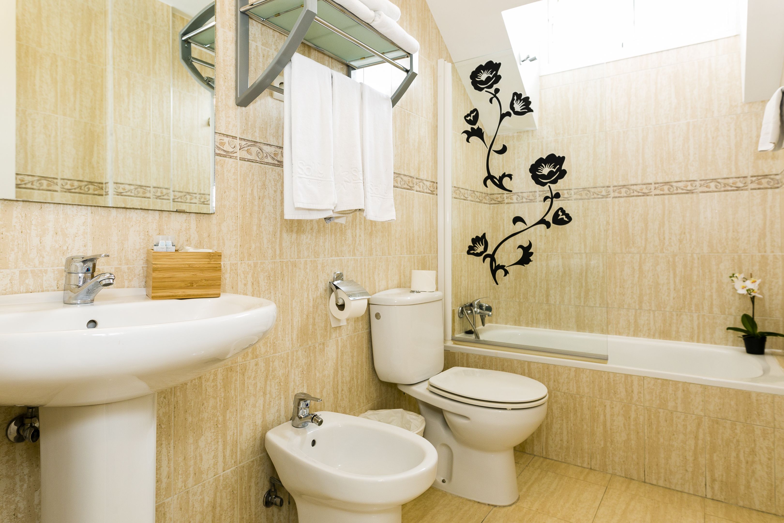 A bathroom with a sink, bidet, toilet, and bathtub.