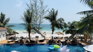 A pool area with lounge chairs, umbrellas, and a view of the beach. - Sunrise Vuth Resort (Koh Rong)